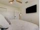 Bright bedroom features a cozy bed, wall-mounted TV, closet, ceiling fan and doorway to another room at 2488 Del Rio Way, Dunedin, FL 34698