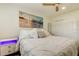 Comfortable bedroom features a plush white bed, beach-themed art, and a ceiling fan for a relaxing retreat at 2488 Del Rio Way, Dunedin, FL 34698
