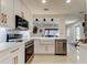 Open concept kitchen with stainless appliances, white cabinetry and view to the living room at 2488 Del Rio Way, Dunedin, FL 34698