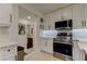 Bright kitchen featuring stainless steel appliances, white cabinetry, and view to a bathroom at 2488 Del Rio Way, Dunedin, FL 34698