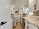 Well-lit laundry room features white cabinetry, marble countertops, and modern appliances for convenient home care at 2488 Del Rio Way, Dunedin, FL 34698