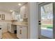 Bright laundry room featuring white cabinets, a marble countertop, and backyard access at 2488 Del Rio Way, Dunedin, FL 34698