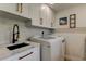 Functional laundry area with sleek black faucet, marble counters, and modern washer/dryer units for everyday convenience at 2488 Del Rio Way, Dunedin, FL 34698