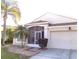 Attractive single-story home boasts a screened-in entryway and a two-car garage, enhanced by palm trees at 25417 Lexington Oaks Blvd, Wesley Chapel, FL 33544