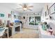 Bright bedroom features a ceiling fan, desk area with computer, and view of the yard through a large window at 2558 Arborwood Dr, Valrico, FL 33596