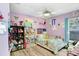 Brightly decorated bedroom with purple walls, ceiling fan, and cozy bed with floral pattern at 2558 Arborwood Dr, Valrico, FL 33596