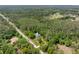 An aerial shot shows the property nestled among tall trees and lush greenery at 346 Ranch Rd, Tarpon Springs, FL 34688