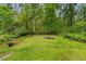 Backyard featuring a fire pit and lush surroundings, creating a serene retreat at 346 Ranch Rd, Tarpon Springs, FL 34688