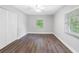 Bright bedroom with wood-look floors, a large window, and a closet with white louvered doors at 346 Ranch Rd, Tarpon Springs, FL 34688