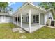 Image shows the back of a home featuring a covered patio with support columns and sliding glass doors at 346 Ranch Rd, Tarpon Springs, FL 34688