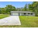 Charming home with a long driveway leading to a two-car garage and beautifully landscaped front yard at 346 Ranch Rd, Tarpon Springs, FL 34688