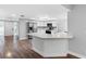 Open-concept kitchen with stainless steel appliances, modern white cabinets, and a breakfast bar overlooking the living area at 346 Ranch Rd, Tarpon Springs, FL 34688