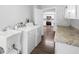 Laundry room with washer, dryer, sink, and door to the kitchen, providing a practical space at 346 Ranch Rd, Tarpon Springs, FL 34688