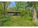 Image shows a wooden livestock enclosure surrounded by a lush green landscape with overgrown grass and diverse foliage at 346 Ranch Rd, Tarpon Springs, FL 34688