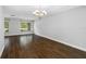 Empty living room with dark wood flooring, new lighting, and large windows at 346 Ranch Rd, Tarpon Springs, FL 34688