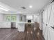 Bright kitchen with white cabinets, and stainless appliances, connected to a living area with fireplace and barn door closet at 346 Ranch Rd, Tarpon Springs, FL 34688