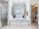 Elegant bathroom with a soaking tub beneath a chandelier, complemented by a separate glass shower at 3625 Gaviota Dr, Ruskin, FL 33573
