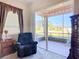 Comfortable bedroom featuring a cozy recliner and a sliding glass door to a screened lanai at 3625 Gaviota Dr, Ruskin, FL 33573