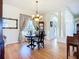 Elegant dining room with hardwood floors, chandelier, and natural light from a large window at 3625 Gaviota Dr, Ruskin, FL 33573