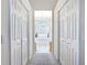 Hallway featuring closet doors leading to a tub beneath a chandelier and bright window at 3625 Gaviota Dr, Ruskin, FL 33573