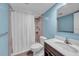 Clean bathroom featuring a shower with white shower curtain and a modern vanity with white countertop and dark wood cabinets at 4725 Cove Cir # 302, St Petersburg, FL 33708