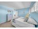 Serene bedroom with blue walls, white linens, dresser, and a view to the doorway offers a peaceful space at 4725 Cove Cir # 302, St Petersburg, FL 33708