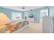 Bright bedroom with floral bedding, white wicker furniture, a ceiling fan, and sliding glass doors to a balcony with water view at 4725 Cove Cir # 302, St Petersburg, FL 33708
