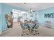 Well lit dining room with a round table and view to the kitchen with an open concept and light blue walls at 4725 Cove Cir # 302, St Petersburg, FL 33708