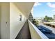 Exterior view from the property of a walkway that looks out to the building, blue tennis courts, and parking lot at 4725 Cove Cir # 302, St Petersburg, FL 33708