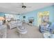 Open living room with comfortable sofas, view of the kitchen, a ceiling fan, and bright windows with water views at 4725 Cove Cir # 302, St Petersburg, FL 33708