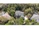 A stunning aerial view of a large, well-maintained home with mature trees and a private tennis court at 5806 Terncrest Dr, Lithia, FL 33547