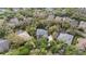 An aerial view of a home with a green roof surrounded by mature trees in a residential neighborhood at 5806 Terncrest Dr, Lithia, FL 33547