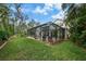 Spacious backyard with mature trees, lush lawn, and a screened-in pool and patio area at 5806 Terncrest Dr, Lithia, FL 33547