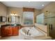 A bright bathroom with a jacuzzi tub, a separate glass shower, and dark wood cabinets at 5806 Terncrest Dr, Lithia, FL 33547