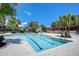 A community pool with clear blue water, sun loungers, and palm trees under a clear blue sky at 5806 Terncrest Dr, Lithia, FL 33547