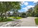 Spacious driveway leading to a two-story home with manicured landscaping, mature trees, and charming curb appeal at 5806 Terncrest Dr, Lithia, FL 33547