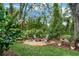 A backyard firepit area with seating, surrounded by lush greenery and landscaping at 5806 Terncrest Dr, Lithia, FL 33547