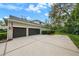 Spacious three-car garage and long driveway, with mature landscaping and an American flag at 5806 Terncrest Dr, Lithia, FL 33547