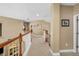 A carpeted upstairs hallway with a wooden railing, neutral walls, and access to several rooms at 5806 Terncrest Dr, Lithia, FL 33547