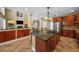 Open kitchen with center island, cherry cabinets, stainless steel appliances, and breakfast bar at 5806 Terncrest Dr, Lithia, FL 33547