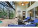Covered patio with outdoor seating, fire pit, grill, and a view of the screened-in pool and spa area at 5806 Terncrest Dr, Lithia, FL 33547