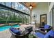 Covered patio with outdoor seating, a fire pit, and a view of the screened-in pool and spa area at 5806 Terncrest Dr, Lithia, FL 33547