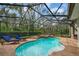 Inviting screened-in pool area with a hot tub, sun loungers, and lush greenery at 5806 Terncrest Dr, Lithia, FL 33547