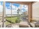 Screened balcony with chairs showcases beautiful views of green space, water, and blue skies at 600 Reserve Ln, Dunedin, FL 34698