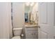 Neat bathroom featuring a toilet, sink with marble countertop, and decorative tile shower with curtain at 600 Reserve Ln, Dunedin, FL 34698