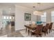 Open-concept dining room features wood flooring, table with six chairs, and modern light fixture at 600 Reserve Ln, Dunedin, FL 34698
