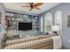Cozy living room with custom built-ins, a ceiling fan, and abundant natural light from arched windows at 600 Reserve Ln, Dunedin, FL 34698