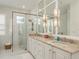 A luxurious bathroom with marble counters, a double vanity, and a glass-enclosed shower at 600 Reserve Ln, Dunedin, FL 34698