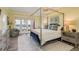 Spacious main bedroom featuring a canopy bed, balcony access with lake view and serene decor at 600 Reserve Ln, Dunedin, FL 34698