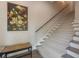 Elegant staircase with carpeted treads and a decorative painting adorning the wall at 600 Reserve Ln, Dunedin, FL 34698